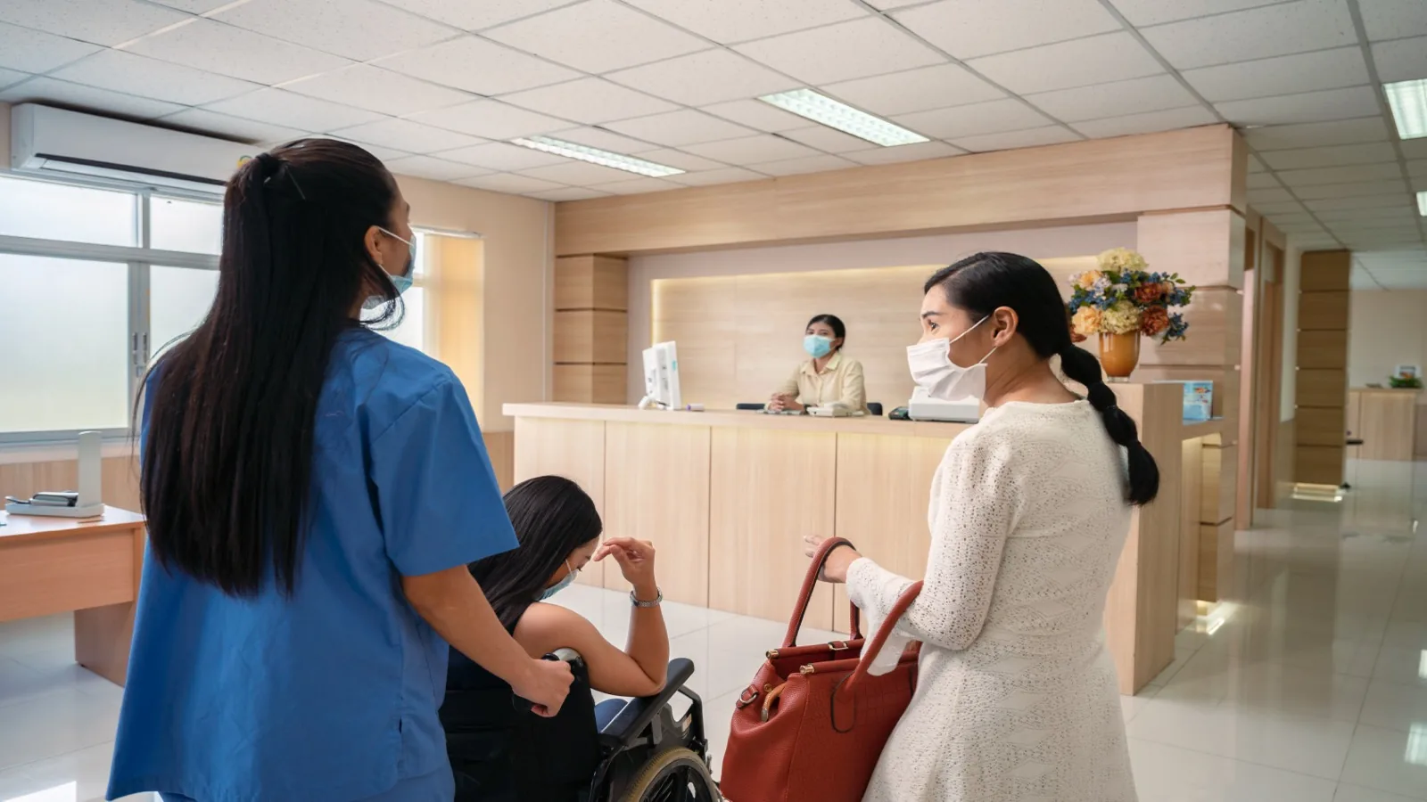 Clinic front desk with staff assisting a patient