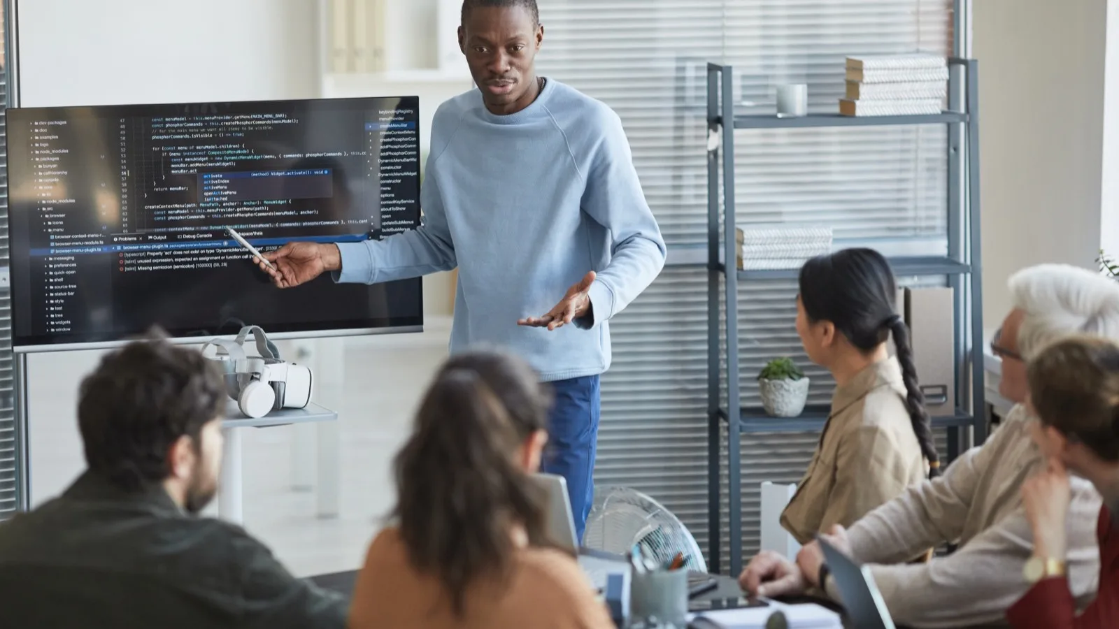 Tech team presenting new technology option with VR headset to colleagues