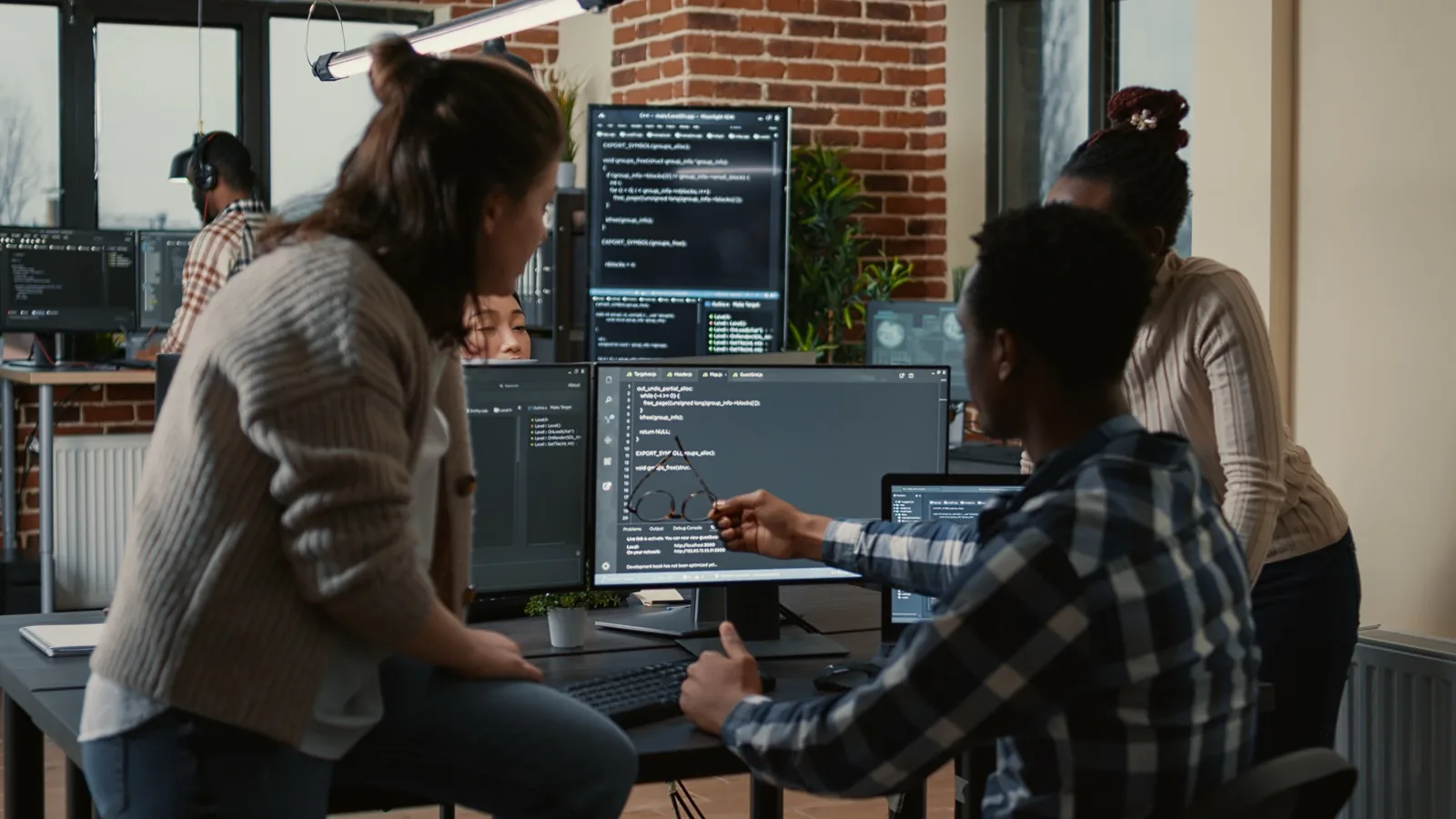 Software developers collaborating on tech stack decisions at a shared workstation