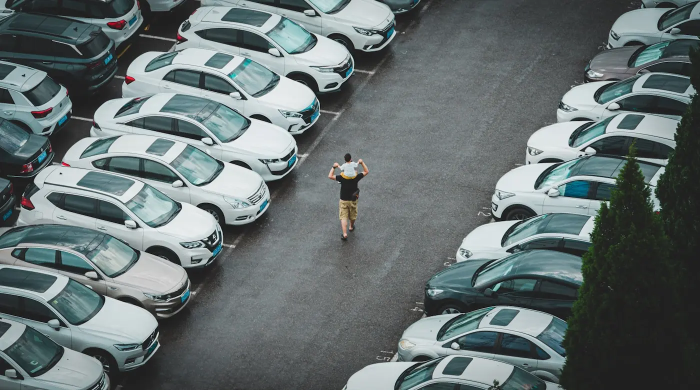 A person walking between rows of vehicles on a dealer lot