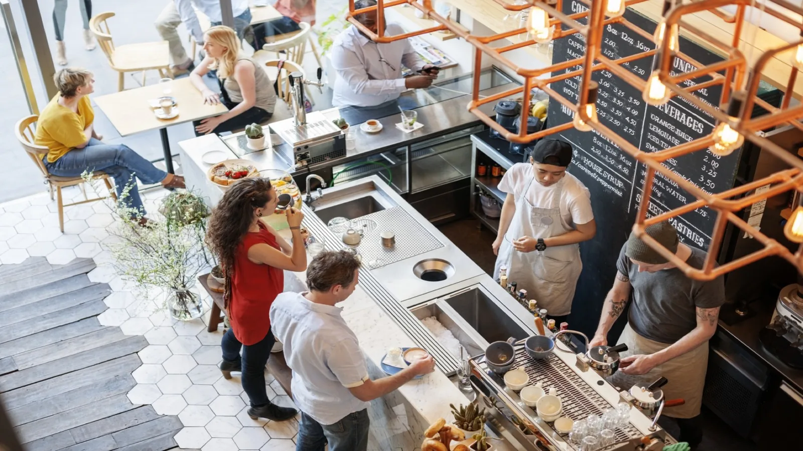 Aerial view of a busy specialty coffee shop with baristas serving customers