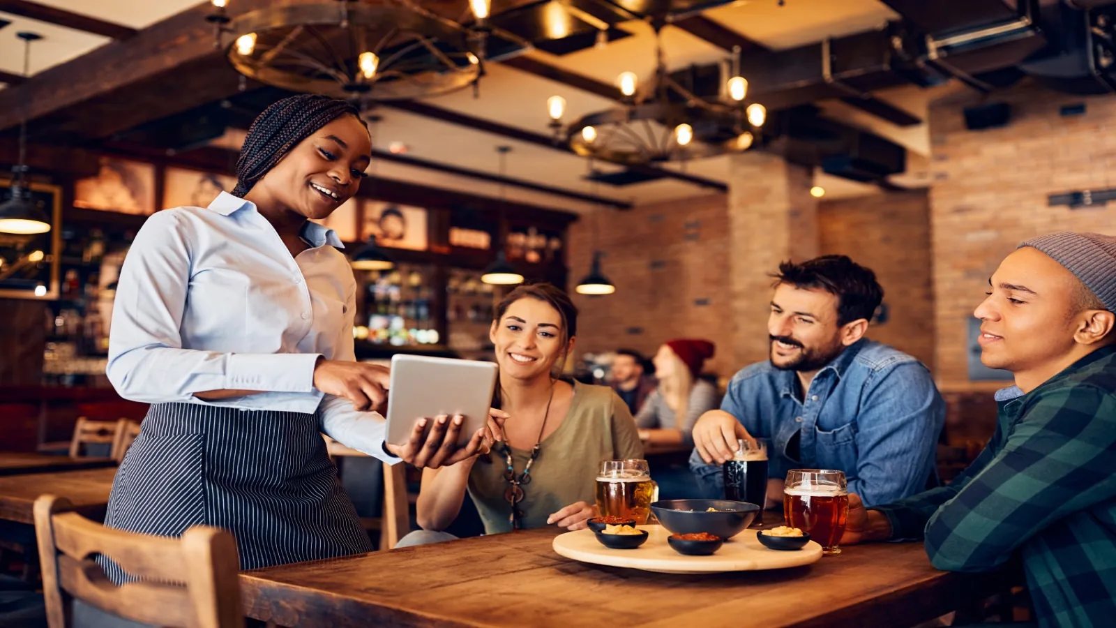Server presenting a tablet with the reservations system to dining guests