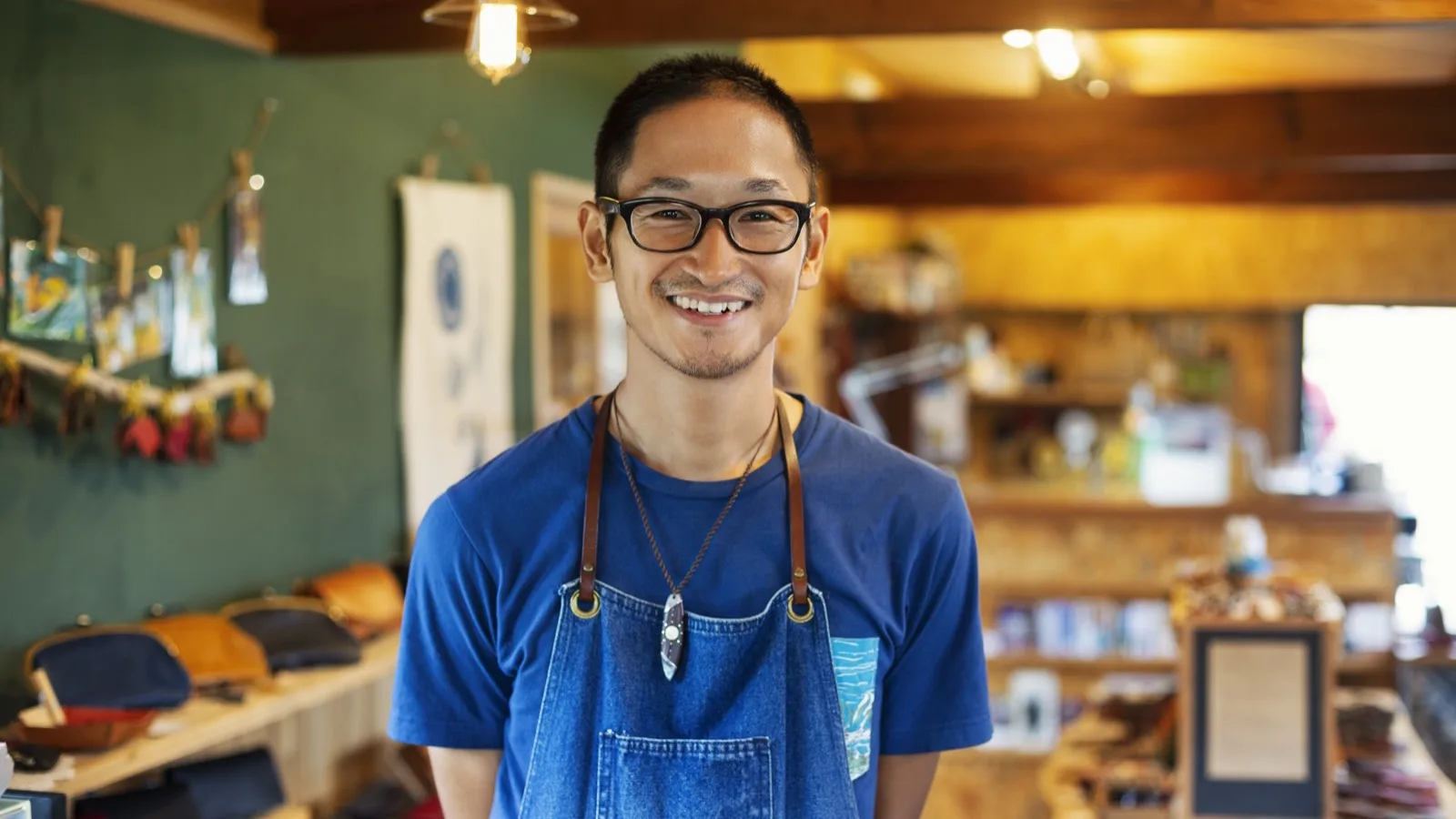 Local small business owner smiling inside his shop with handcrafted goods
