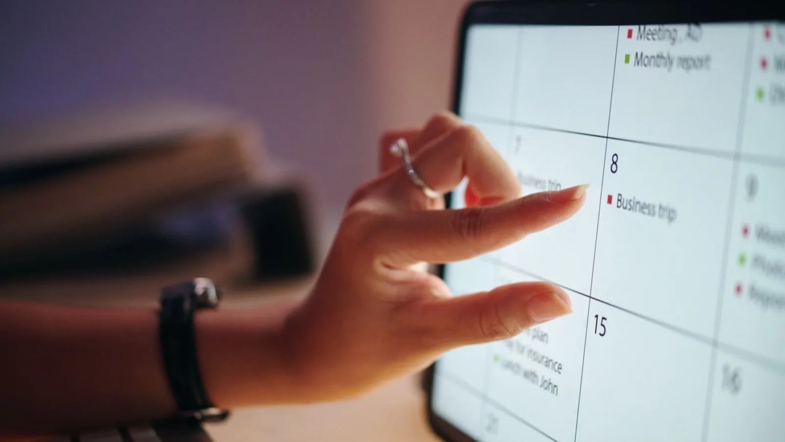 Hand pointing at digital calendar planning business timeline on laptop