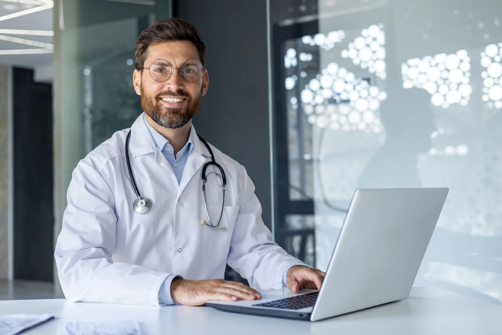 Médico sonriente en su consultorio, listo para atender pacientes