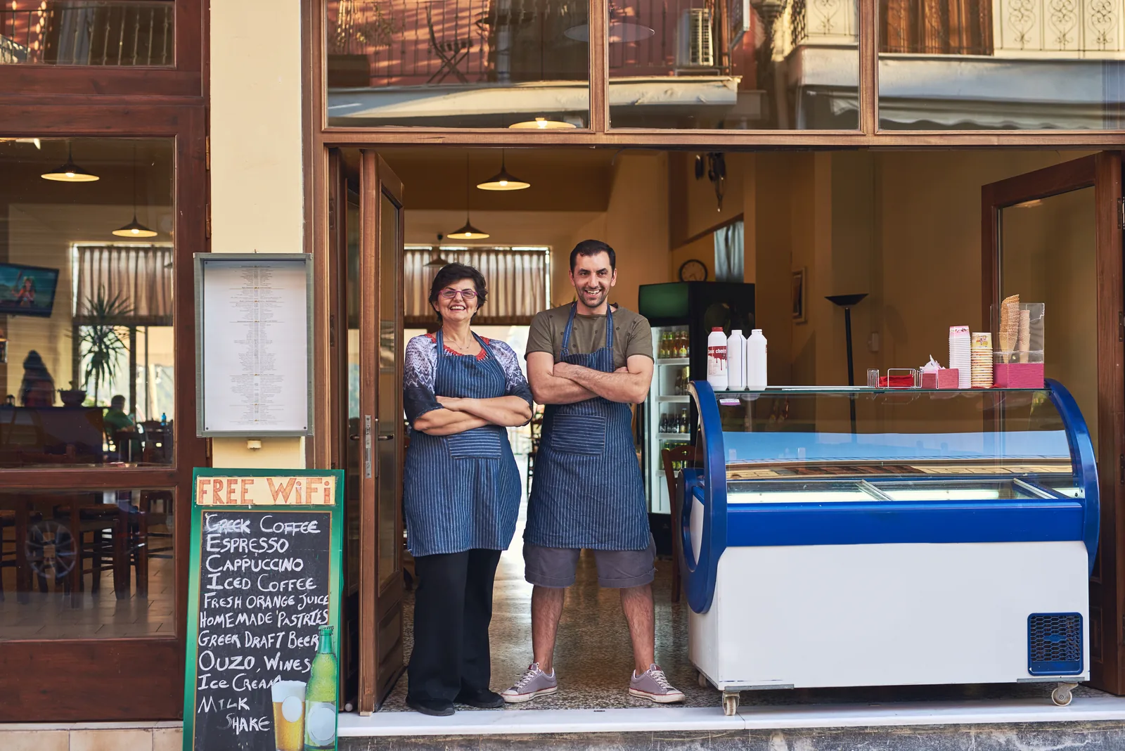 Dueños de un negocio familiar sonriendo en la entrada de su local
