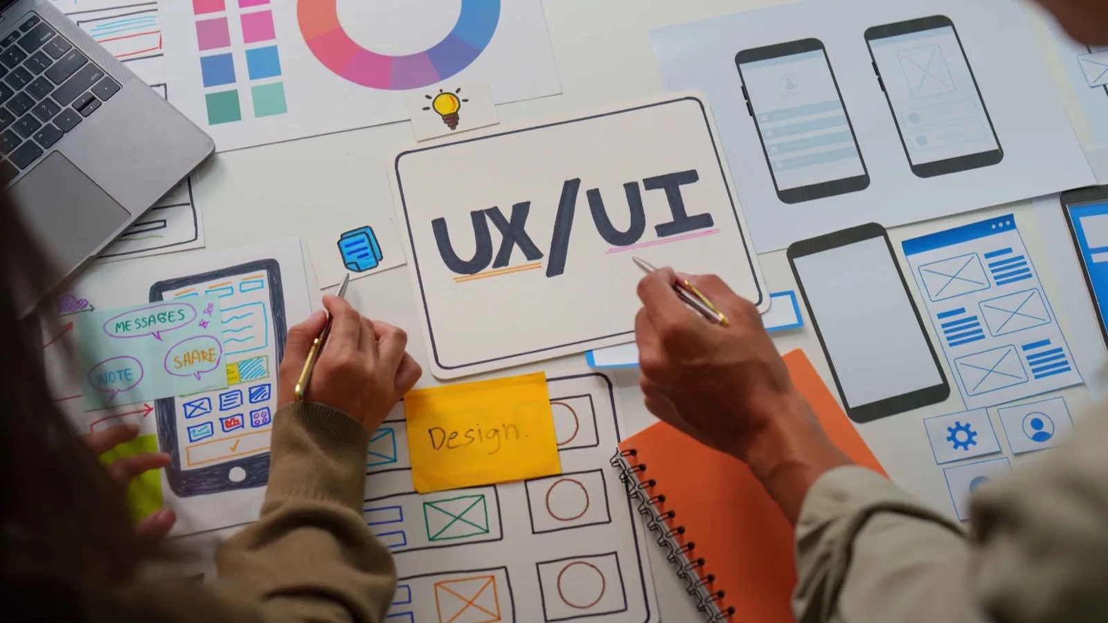 Top-down view of UX/UI design audit with color palette, wireframes, and sketches