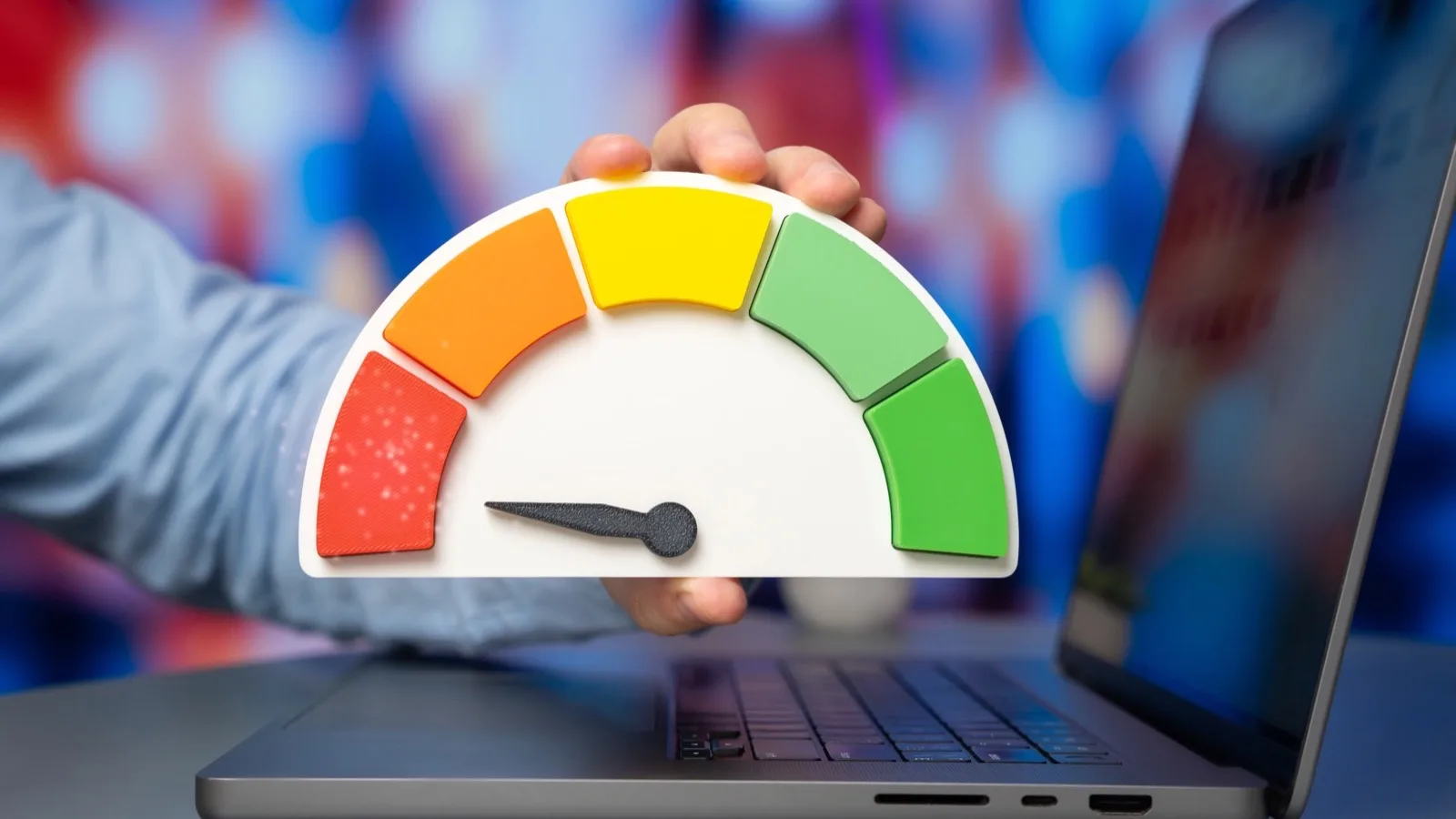 Performance score meter with red yellow green zones in front of laptop screen