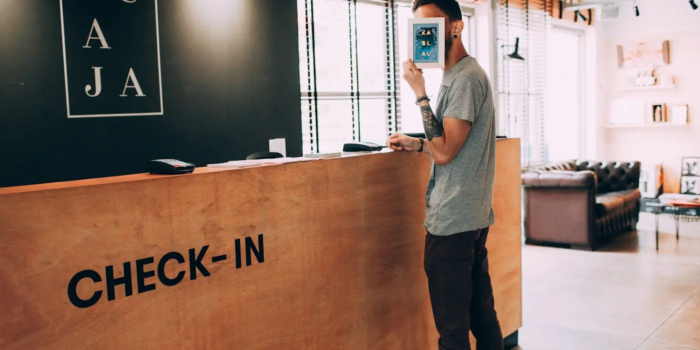 Un huésped en el mostrador de check-in de un hotel pequeño