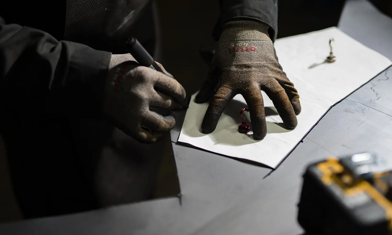 A gloved hand filling out a paper ticket in the field