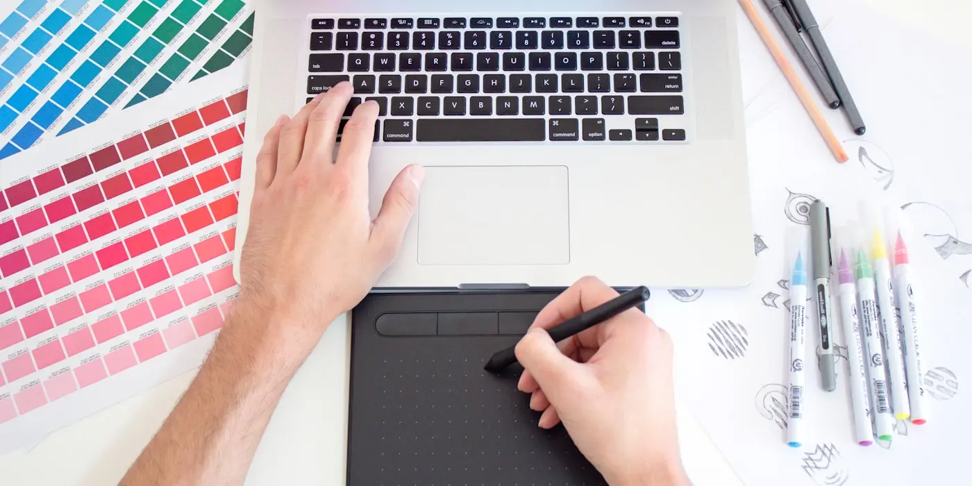 Una diseñadora trabajando un diseño con tableta y muestras de color